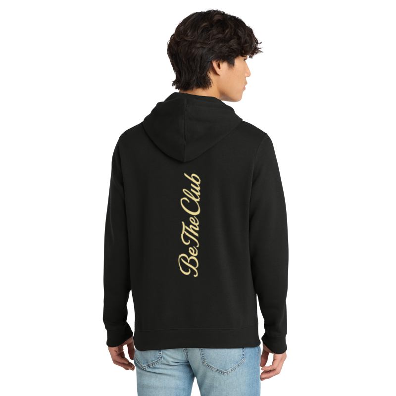 Person wearing a black hoodie with 'Be The Club' text on the back, standing against a white background