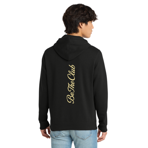 Person wearing a black hoodie with 'Be The Club' text on the back, standing against a white background