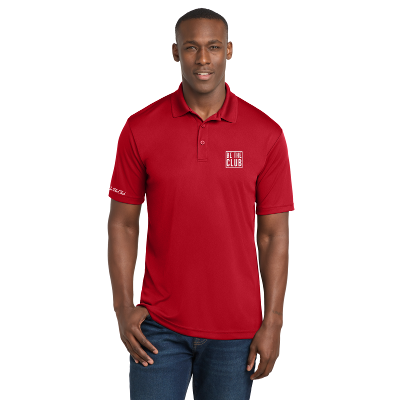 Man wearing a red polo shirt with a logo on a white background