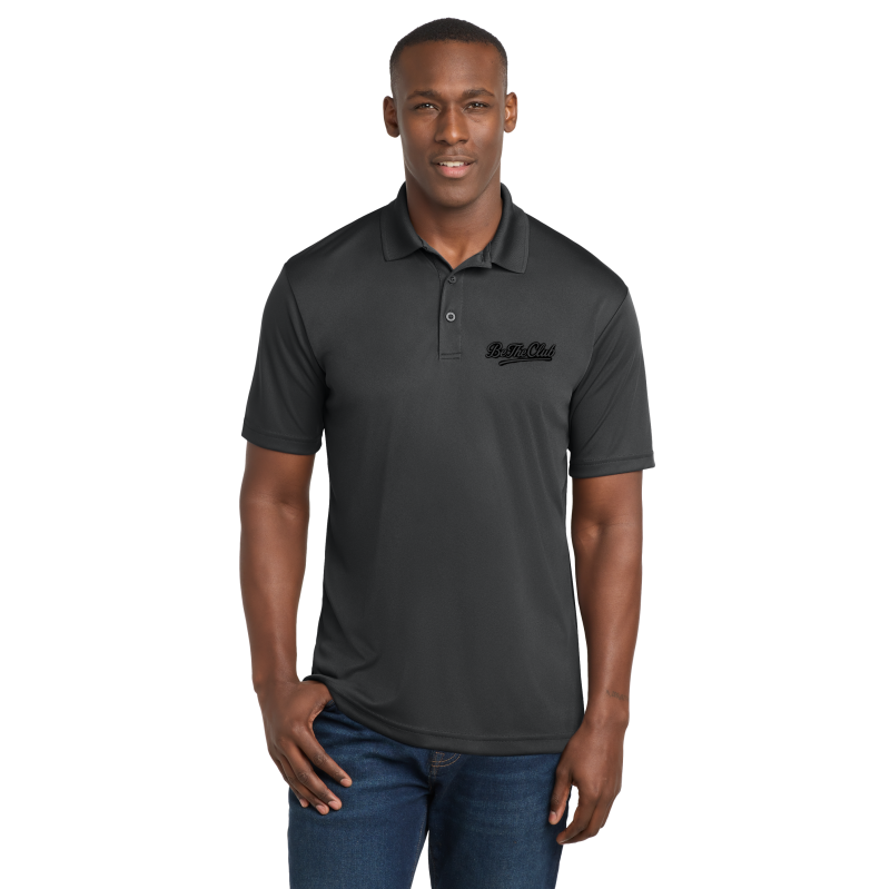 Man wearing a dark gray polo shirt with a logo on a white background